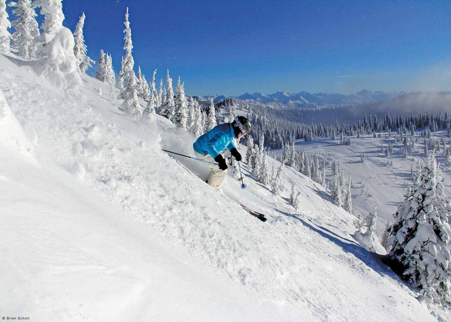 Whitefish Mountain Resort in USA - a person skiing down a snow covered mountain.