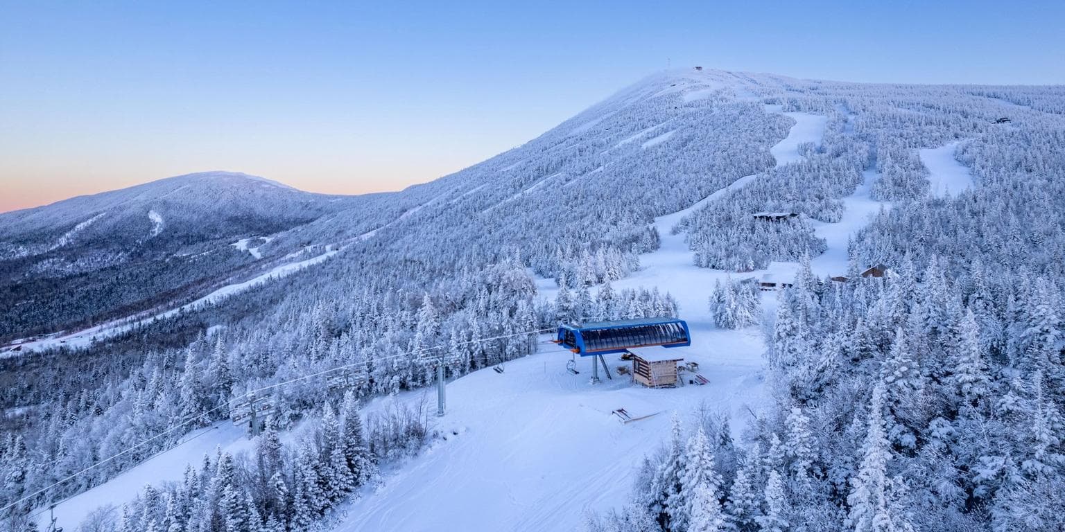 Sugarloaf Mountain in USA: a ski resort surrounded by snow covered trees.