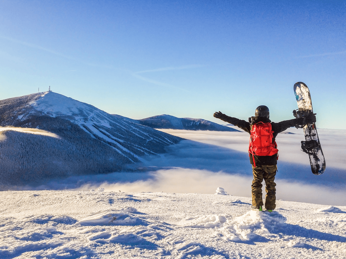 Sugarloaf Mountain in USA - a man standing on top of a snow covered mountain.