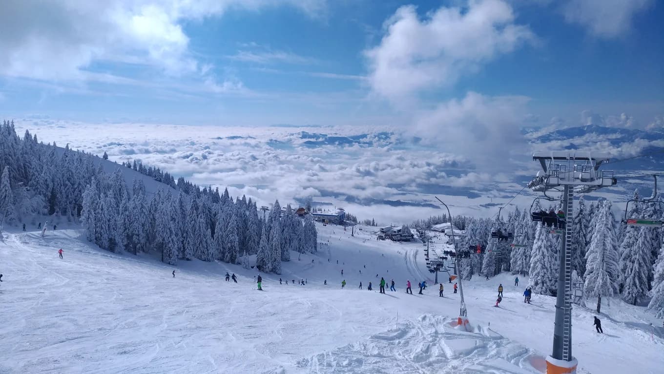 Krvavec in Slovenia - a ski slope with people skiing down it.