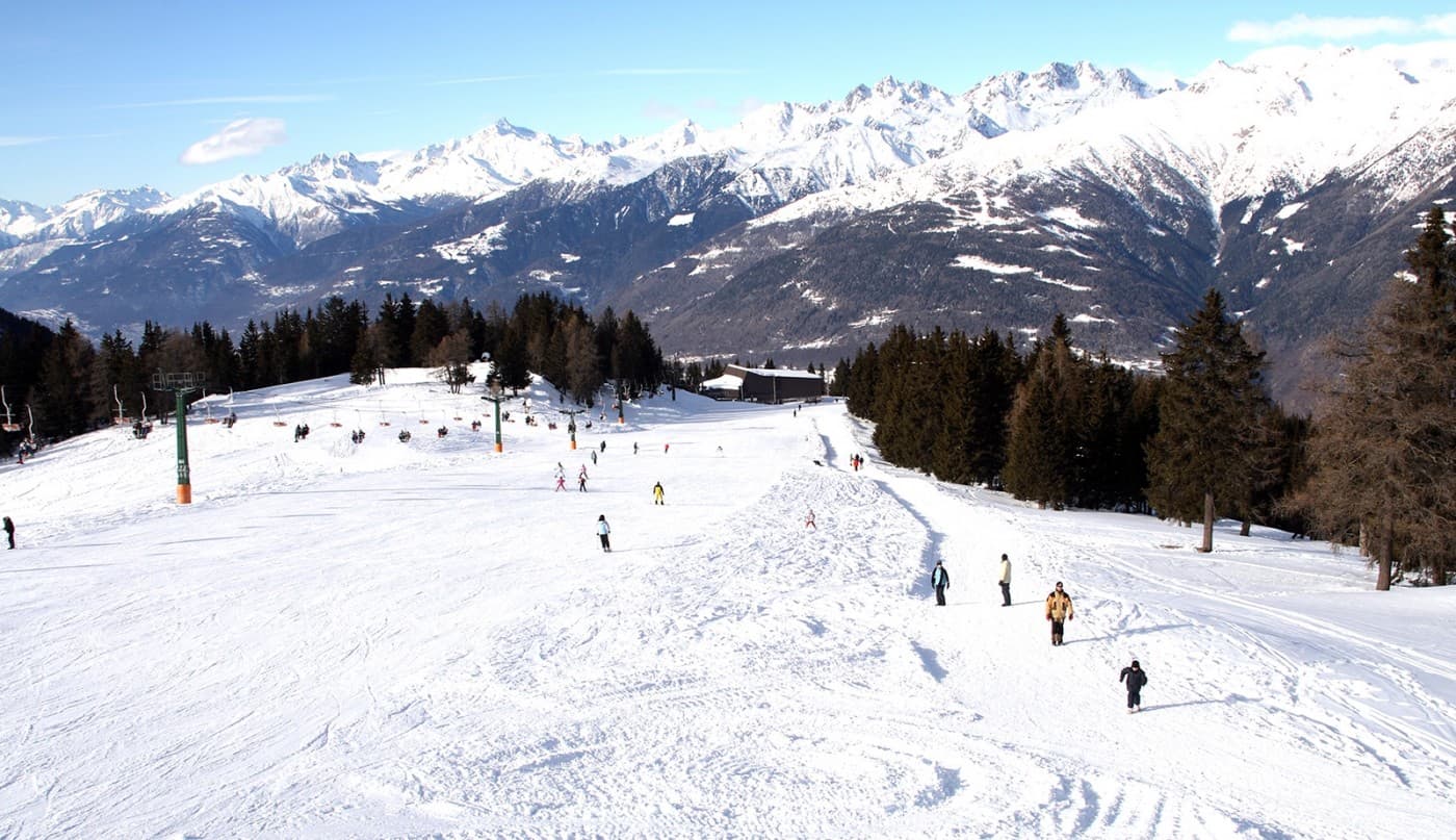 Aprica in Italy - a group of people skiing down a snowy slope.