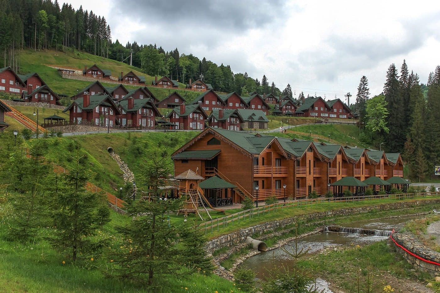 Bukovel in Ukraine - a row of wooden houses on a hillside.