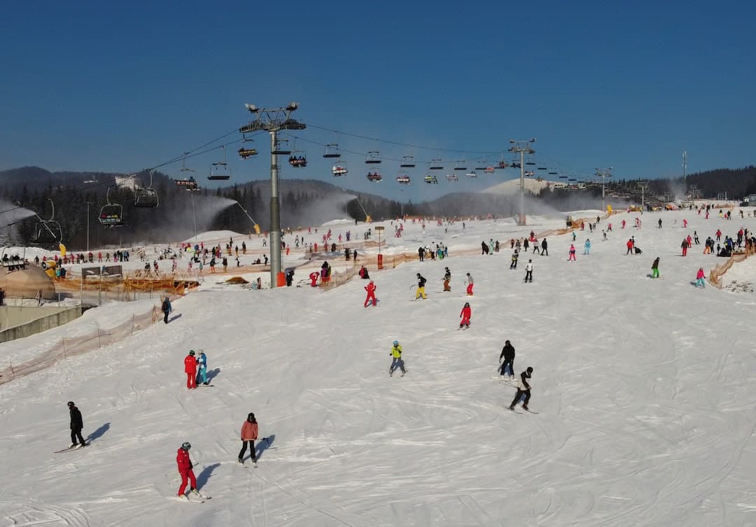 Bukovel in Ukraine - a group of people skiing down a ski slope.