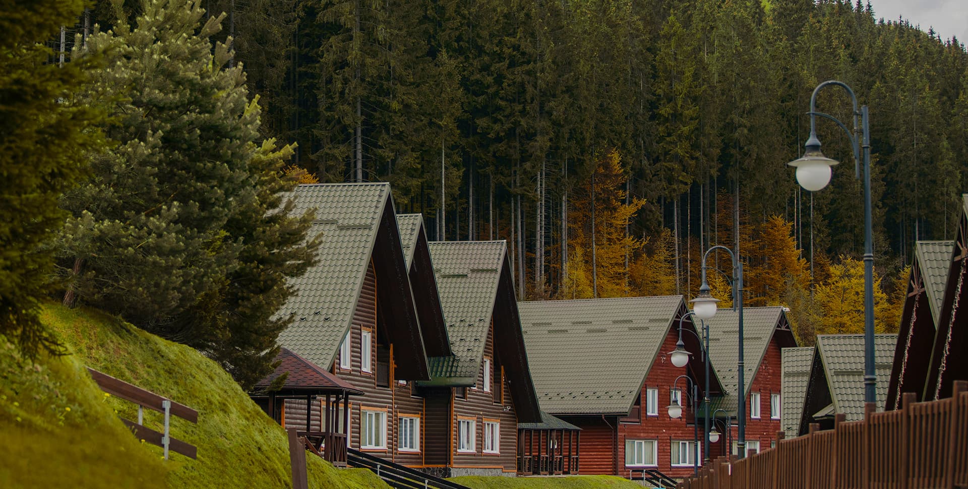 Ski resort in Bukovel, Ukraine featuring a lodge and challet nestled among a forest of trees, with a mountain hut near the foot of the slope.