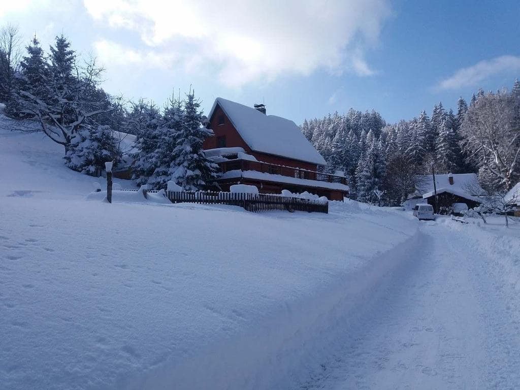 Pod Soláněm in Czech Republic - a red house in the middle of a snowy forest.