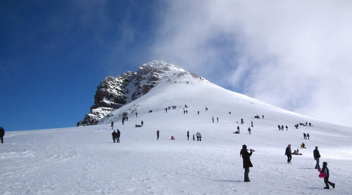Winter sports scene at Matroosberg, Western Cape, South Africa featuring a ski resort nestled against a majestic mountain with a cozy challet nearby.