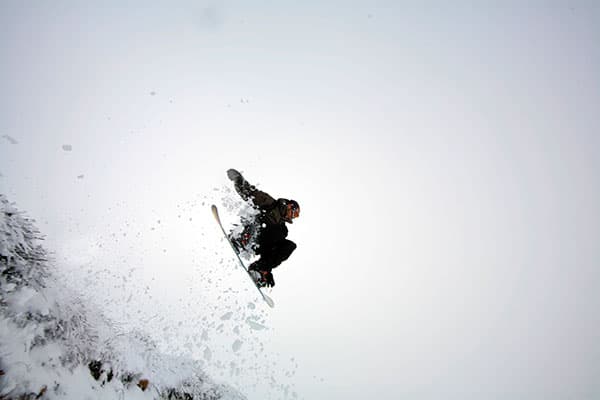 A snowboarder carving through fresh powdery snow on the slopes of Matroosberg in the Western Cape South Africa.