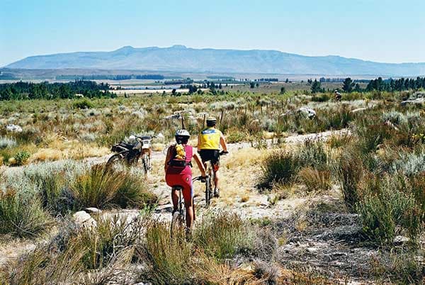 Mountain biker enjoying a ride near a chalet on a sunny day at Matroosberg, Western Cape, South Africa.