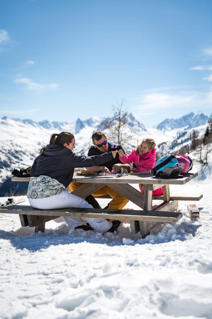 Winter sports scene at Karellis in Savoie Mont Blanc France featuring a ski resort a chalet and a family enjoying skiing activities.