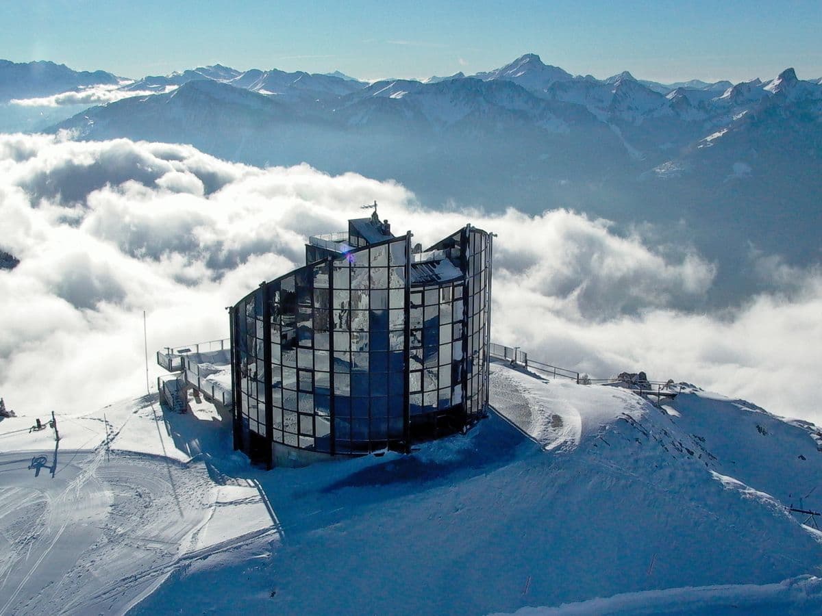 Leysin in Switzerland: a building on top of a mountain surrounded by clouds.