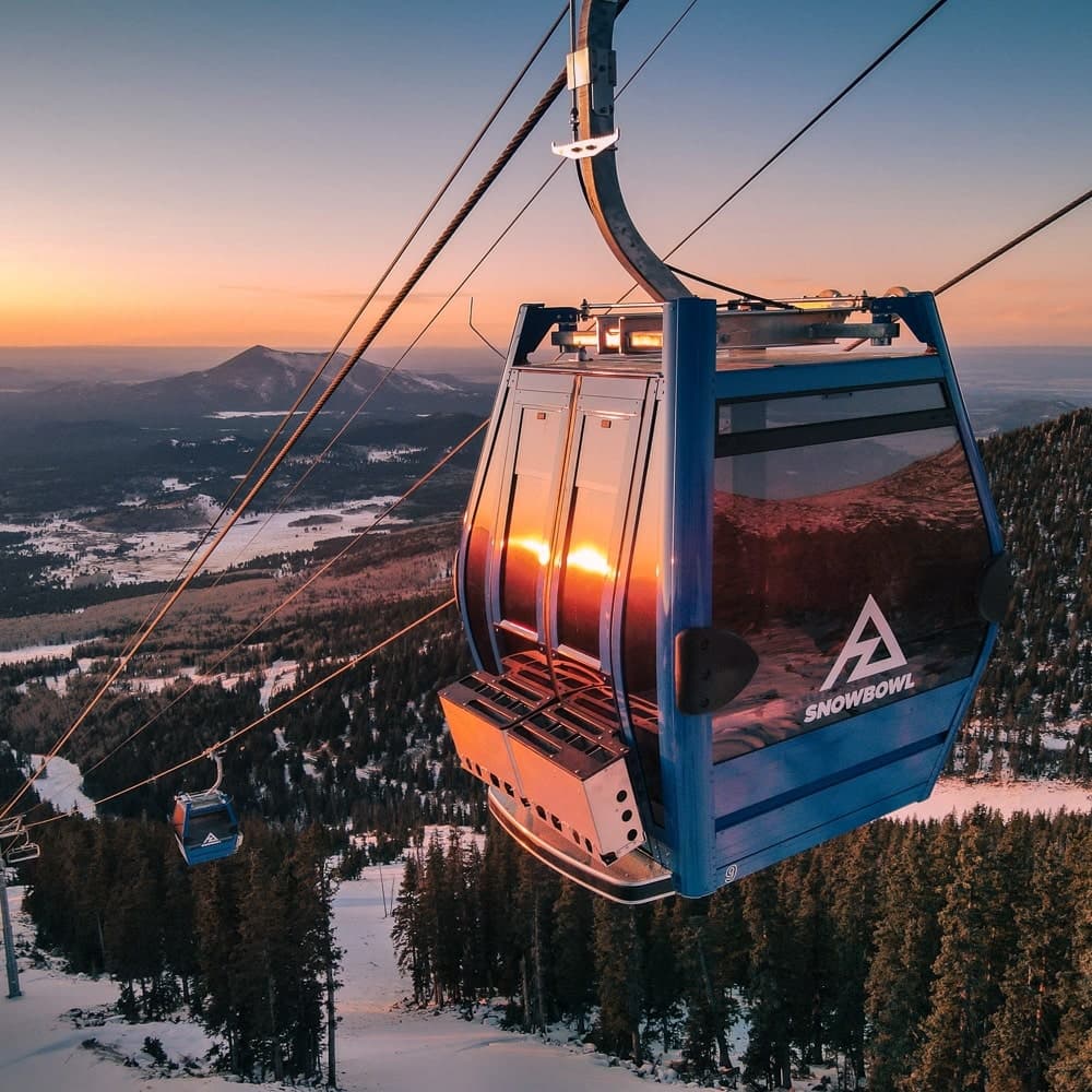 Arizona Snowbowl in USA - a ski lift with the sun setting in the background.