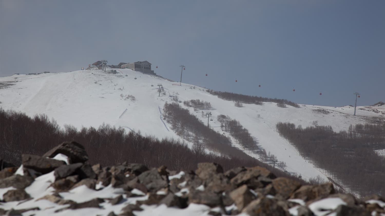 Thaiwoo Ski Resort in China - a mountain covered in snow with a ski lift.