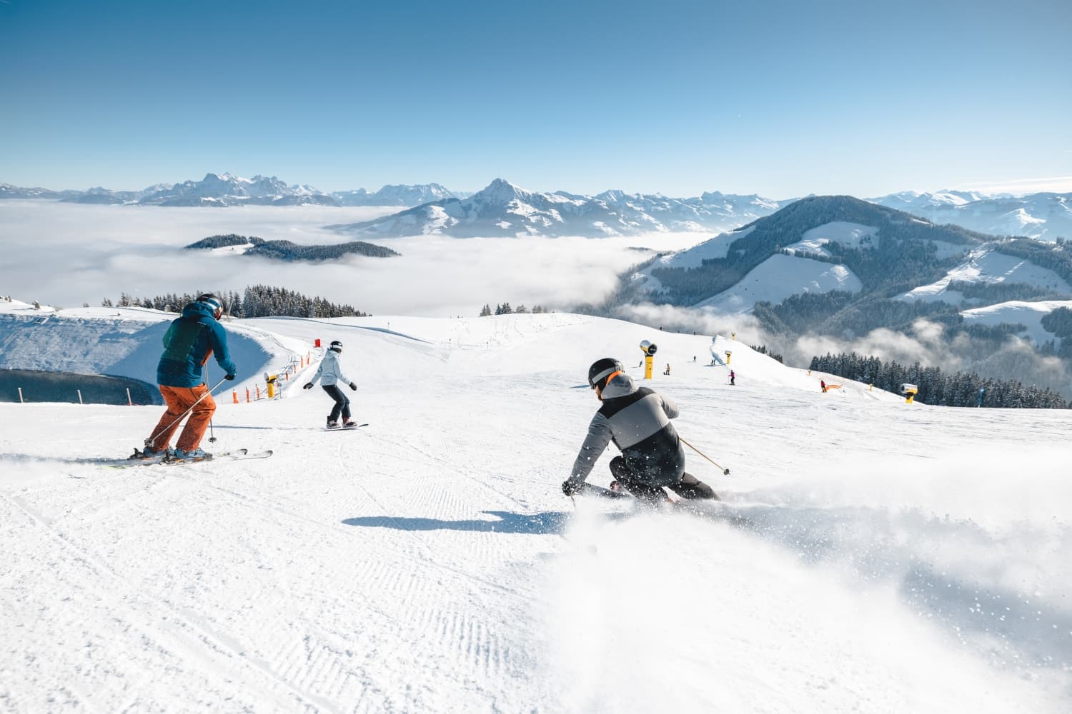 Kaisers in Austria - a group of people riding down a snow covered slope.