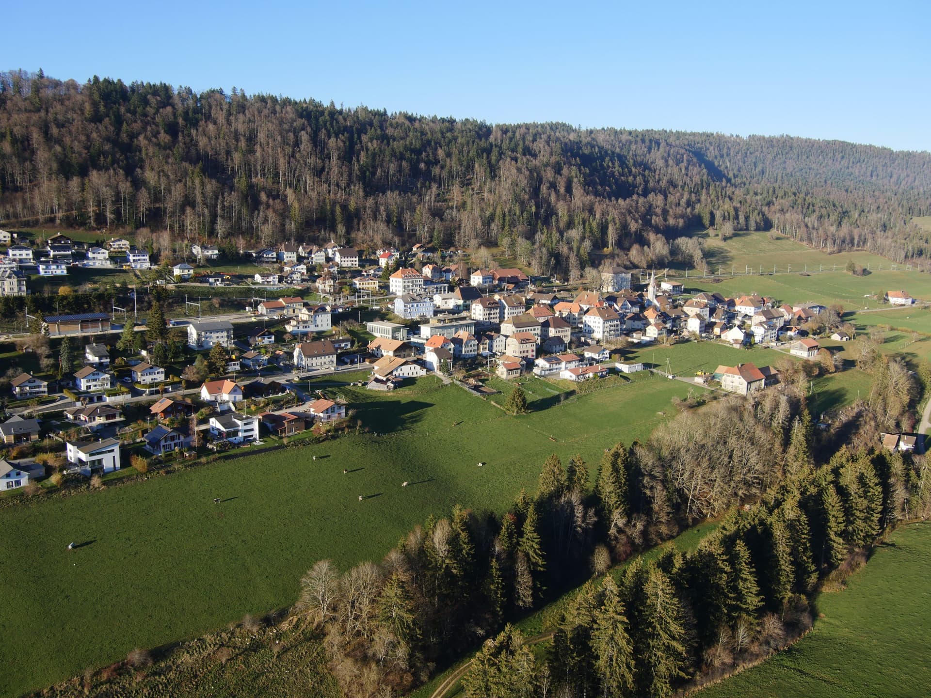 Renan in Switzerland - an aerial view of a small town in the mountains.