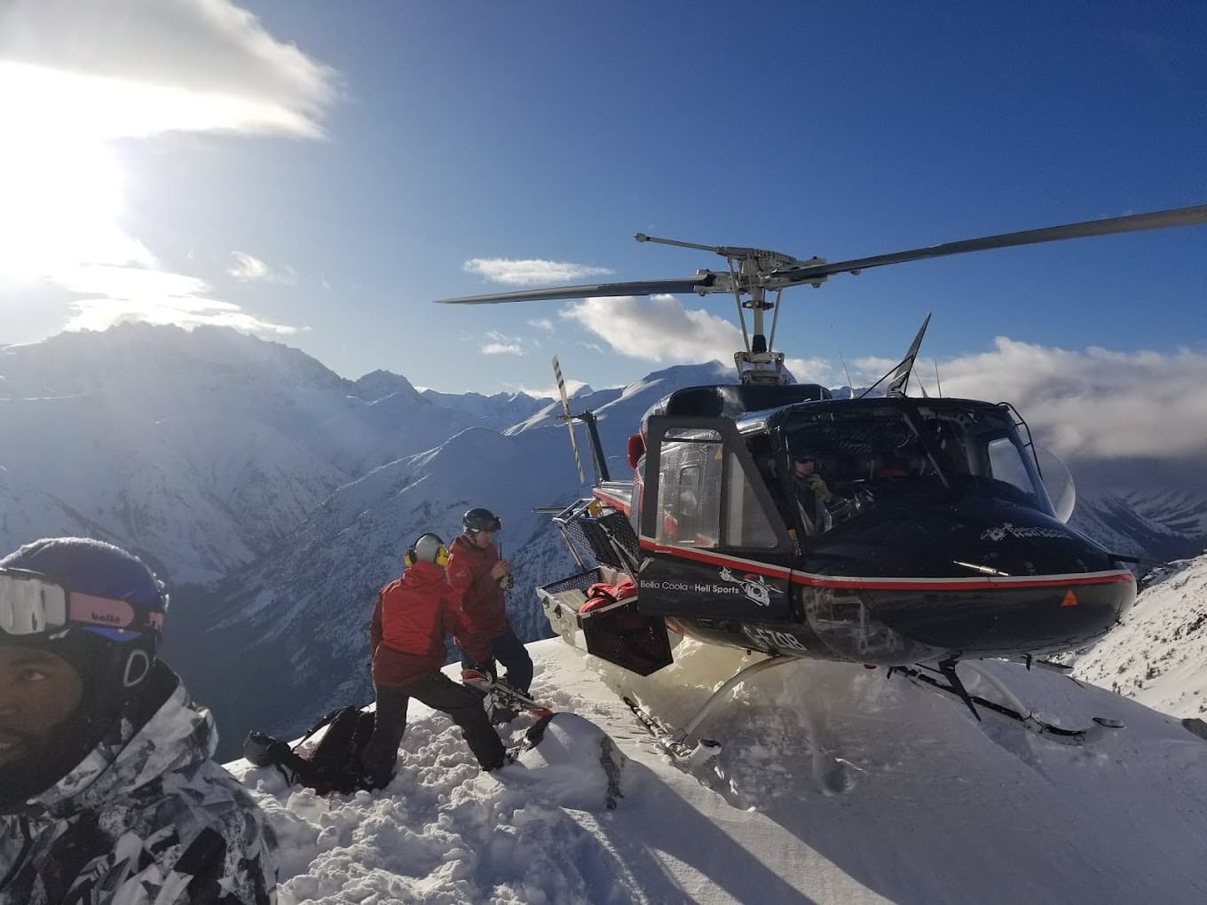 A skier and a family enjoying winter sports at a ski resort on Cariboo Chilcotin Coast British Columbia Canada with a stunning panorama of the mountain range in the background.