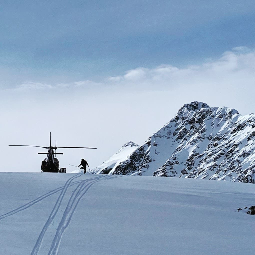 Winter sports enthusiasts enjoy skiing at the Pantheon resort in Cariboo Chilcotin Coast, British Columbia, Canada, with visible ski lifts and groups of people carving down the snowy slopes.
