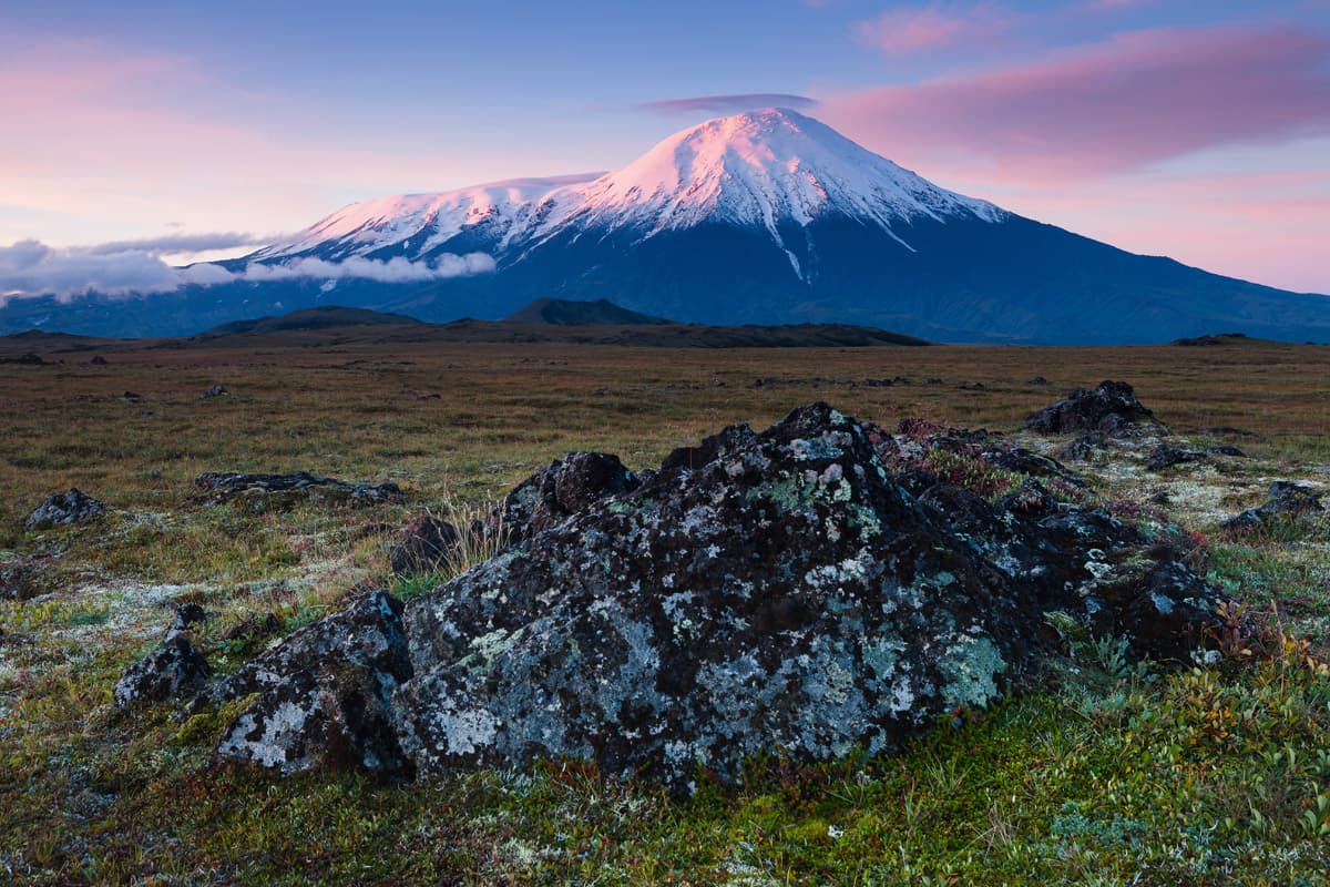 Kamchatka in Russia - a mountain with a snow covered peak in the background.