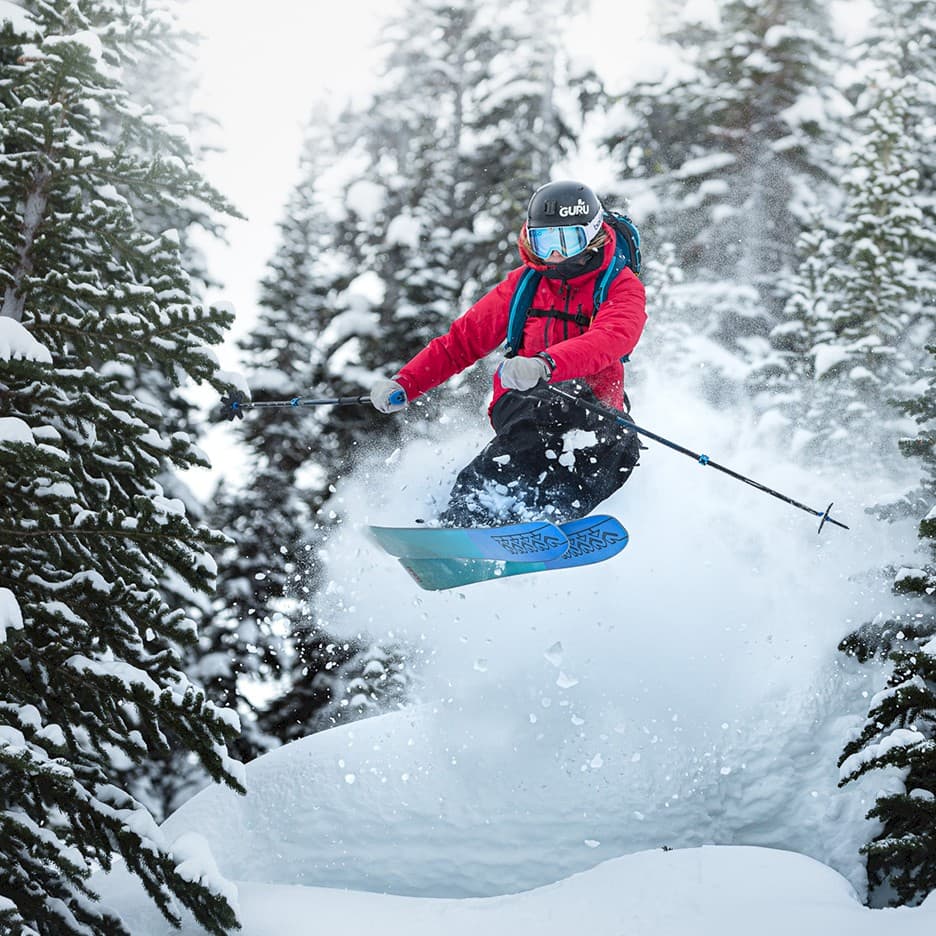 Tyax Heliskiing in Canada - a person jumping in the air on a snowboard.