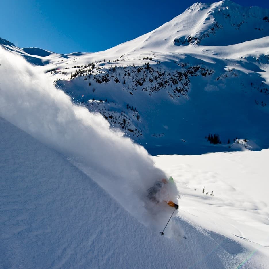 Tyax Heliskiing in Canada - a person skiing down a snow covered mountain.