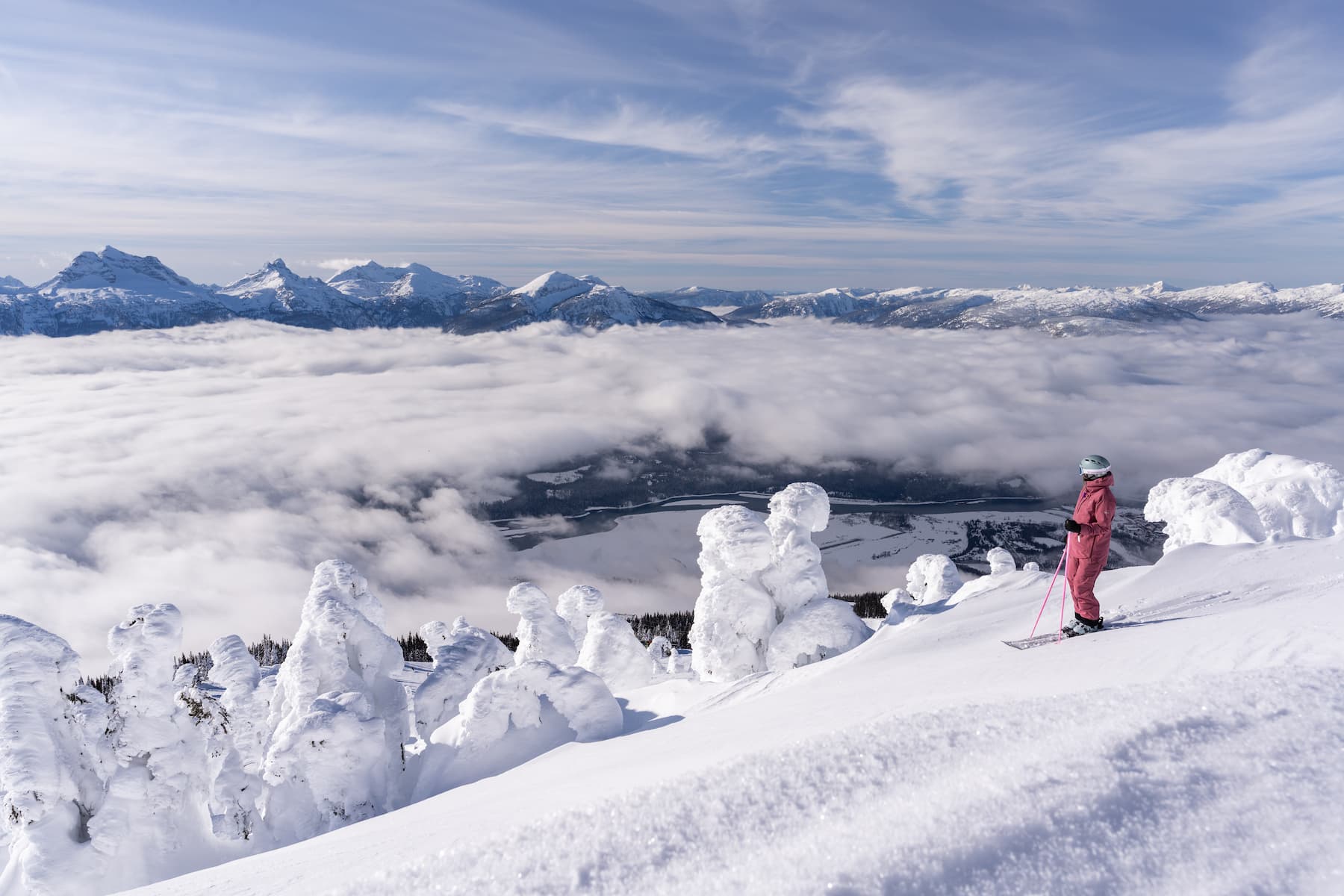 A skier and a snowboarder enjoying winter sports at a ski resort in Kootenay Nelson British Columbia Canada surrounded by breathtaking winter scenery.