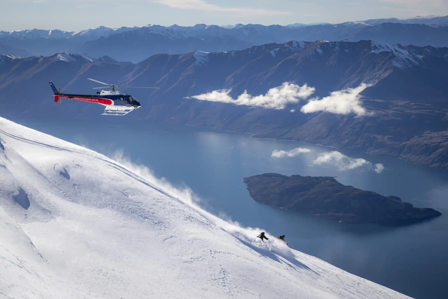 Wilderness in New Zealand - a helicopter flying over a snow covered mountain.