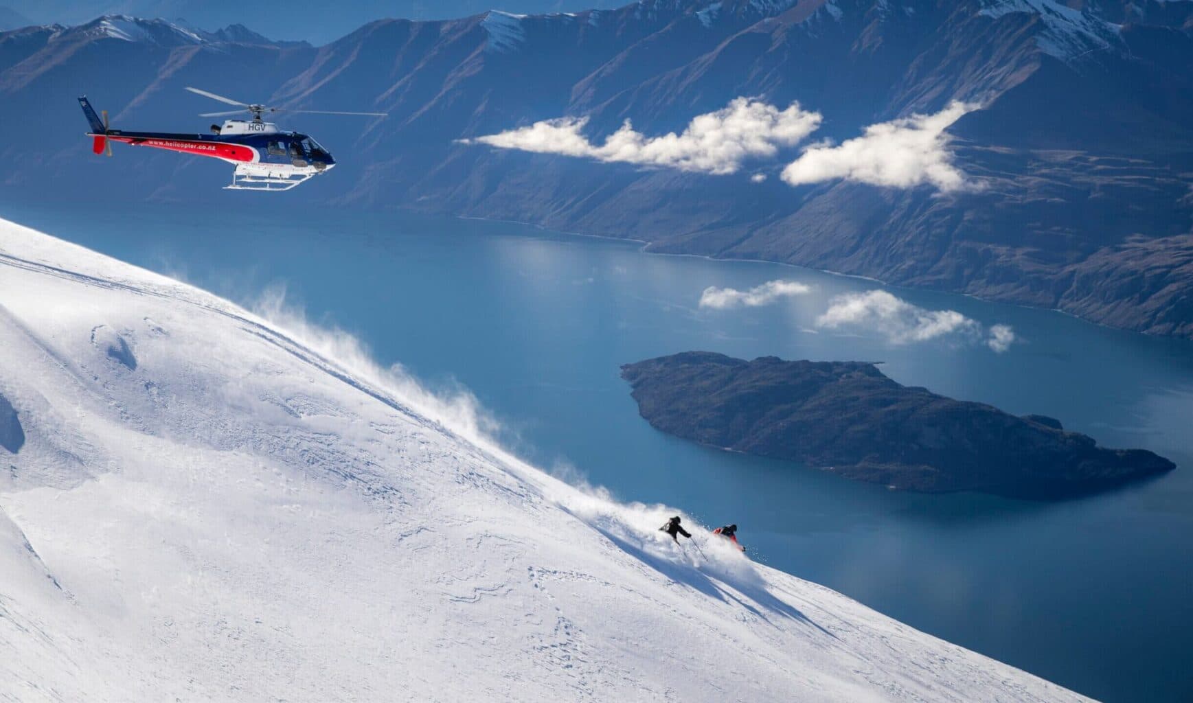 Wilderness in New Zealand - a helicopter flying over a snow covered mountain.