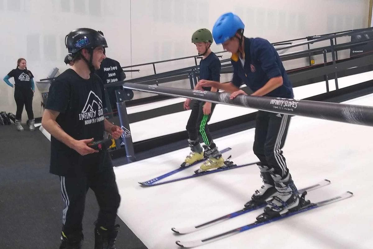 Infinity Slopes – Loveland in USA - a couple of people that are standing on skis.