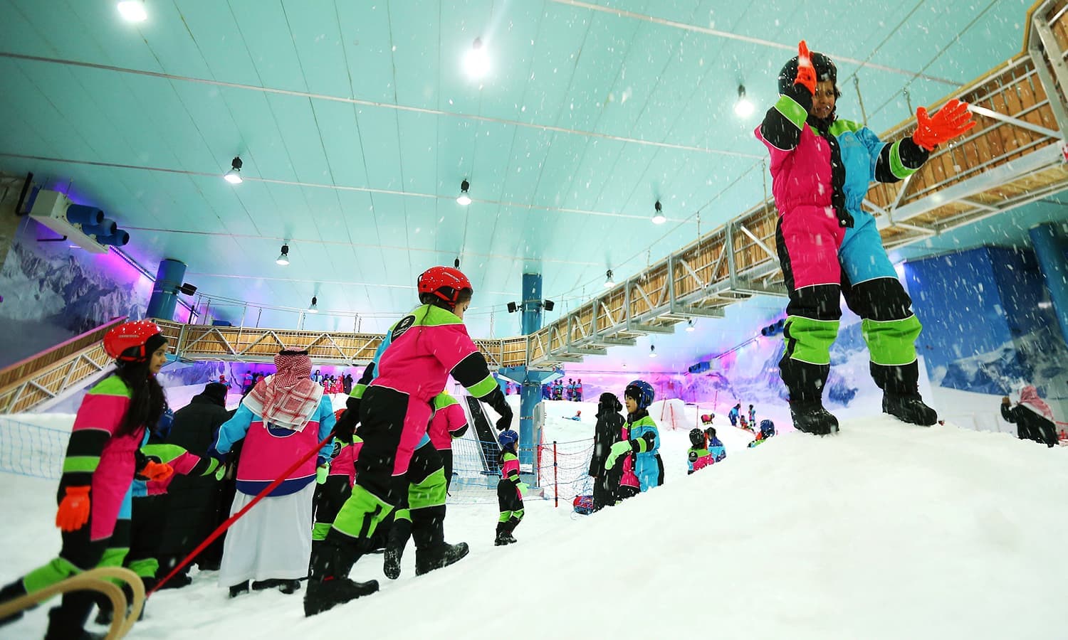 Snow City – Riyadh in Saudi Arabia - a group of people standing on top of a snow covered slope.