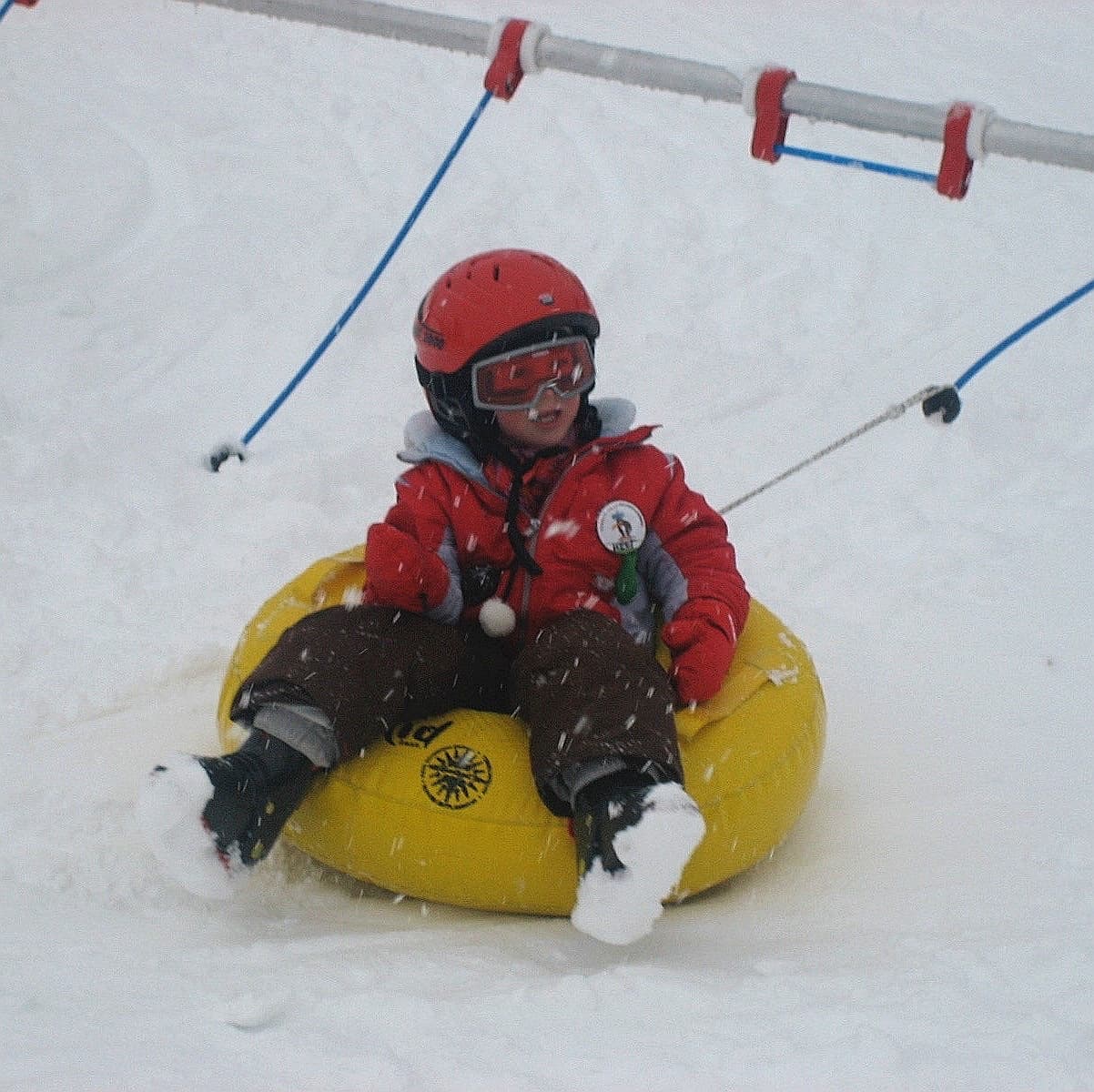 SkiRun – Heerhugowaard in Netherlands - a small child riding on a snow tube.