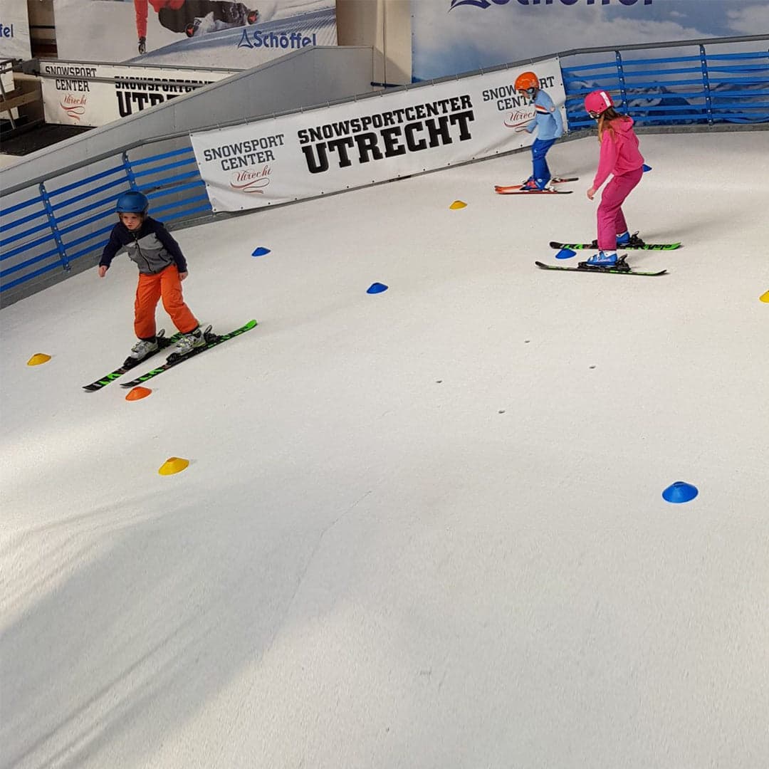 SnowSportCenter Utrecht in Netherlands - a group of people riding ski boards down a slope.
