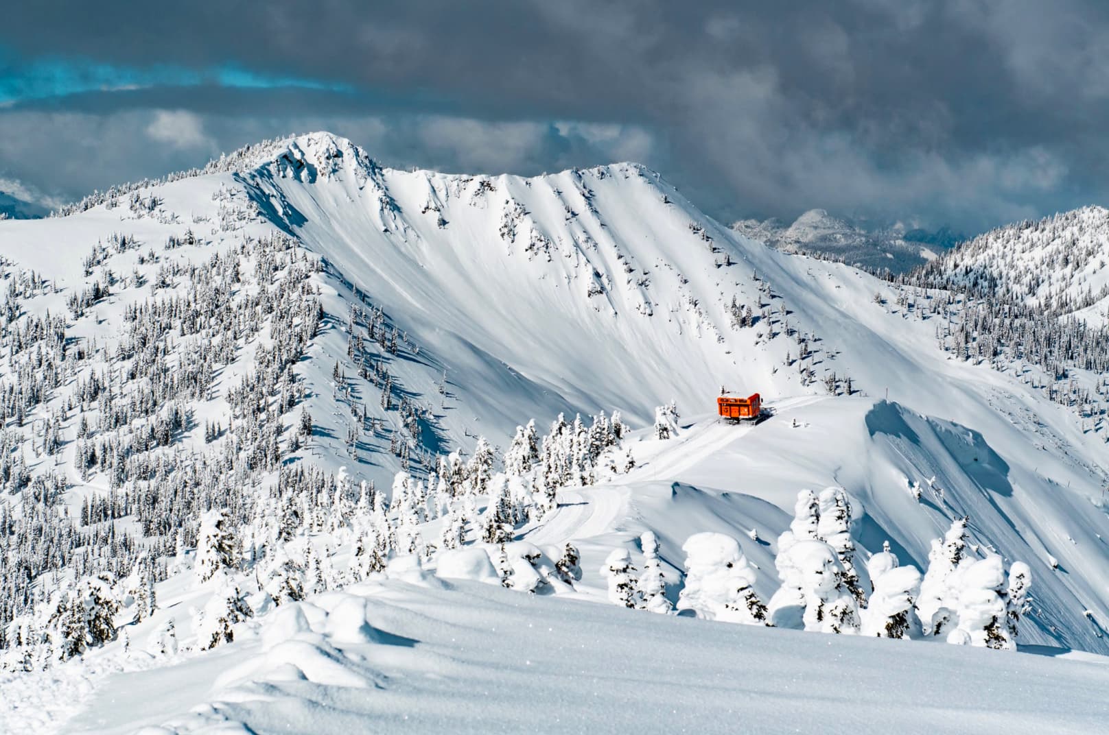 Highland Powder Cat Skiing in Canada - a person skiing down a snow covered mountain.