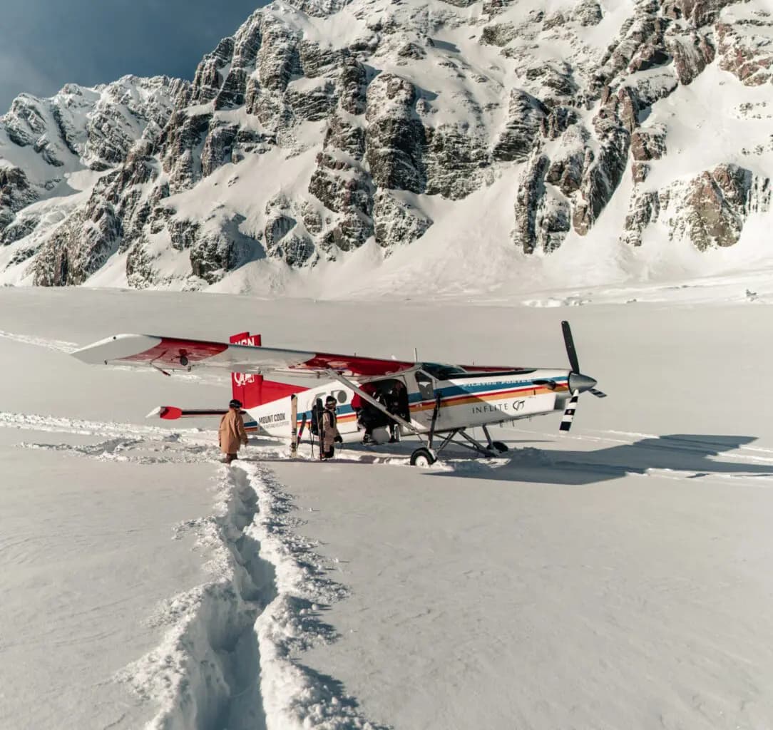 Tasman Glacier in New Zealand - a small plane sitting on top of a snow covered mountain.