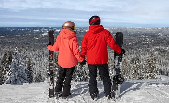 A family enjoying a day of skiing at Dodge Ridge resort in Pinecrest, California, amidst stunning winter scenery featuring a ski lift.
