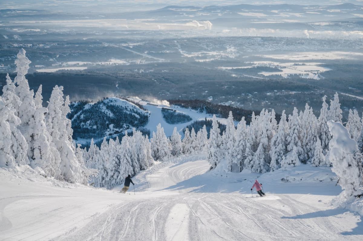 Mont-Orford in Canada - a person skiing down a snow covered mountain.