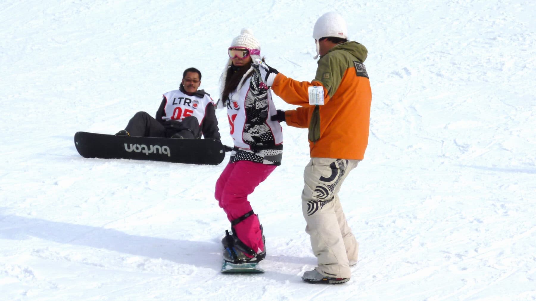 Snova Kobe Free-ku – Kobe in Japan - a man is helping a child on a snowboard.