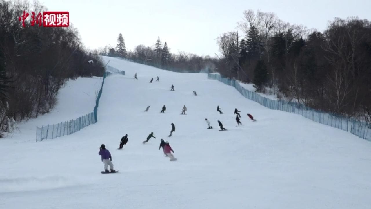 Jinhui Pekín in China - a group of people riding down a snow covered slope.
