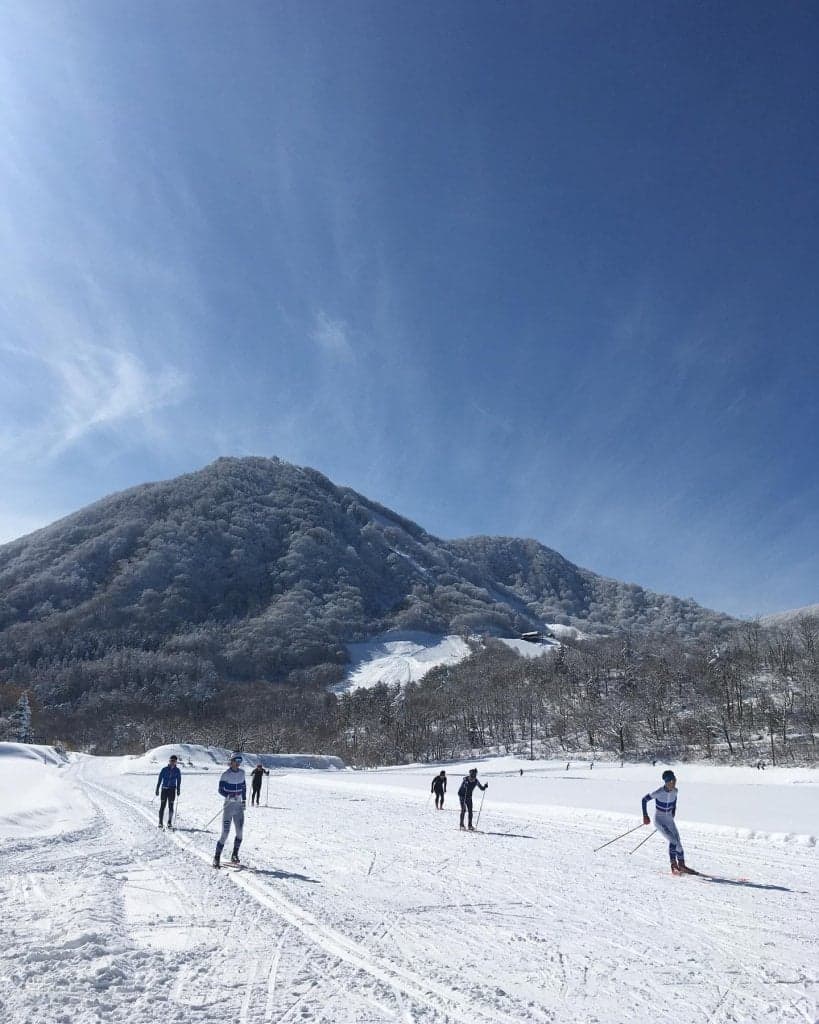 Nikko Yumoto in Japan - a group of people skiing down a snow covered mountain.