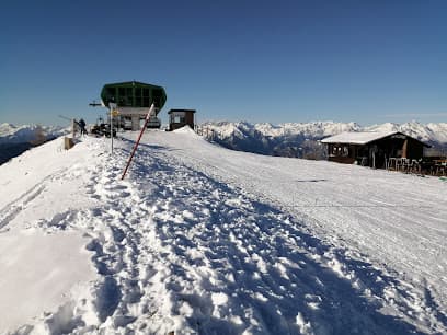 Ski resort at Wasserngrat Bergbahnen in Gstaad, Switzerland, featuring a ski lift heading to the snowy slopes, a winter sports scene, and a chalet nestled in the serene snow-covered landscape.