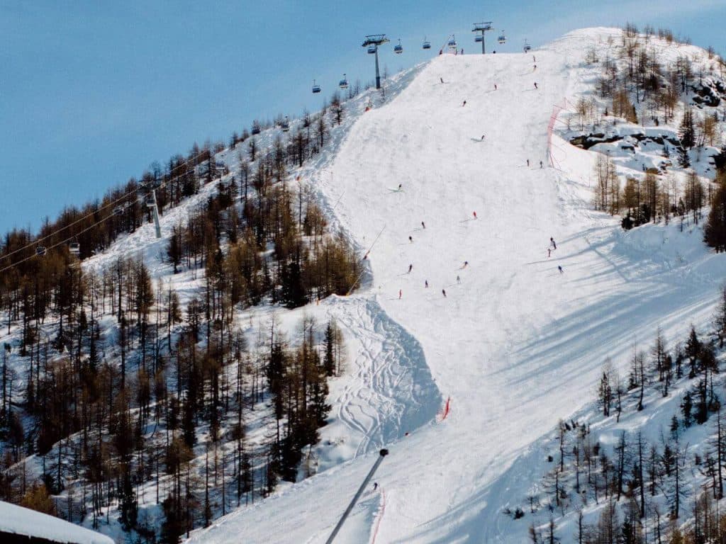 Valmalenco Bernina in Italy - a ski slope with people skiing down it.
