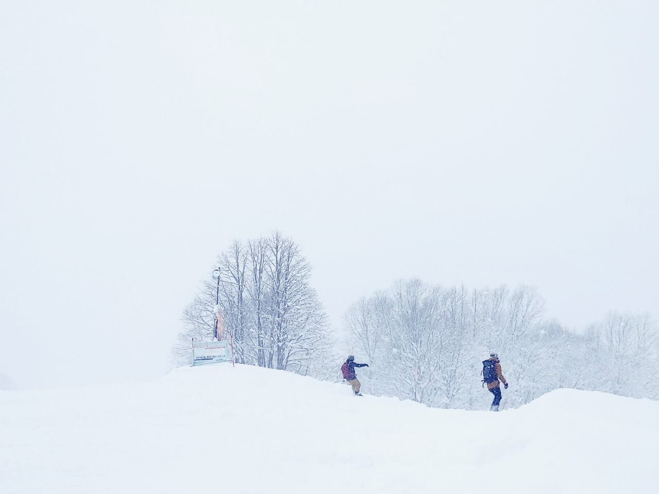 Myoko Akakura Kanko in Japan - two people walking through a snow covered field.