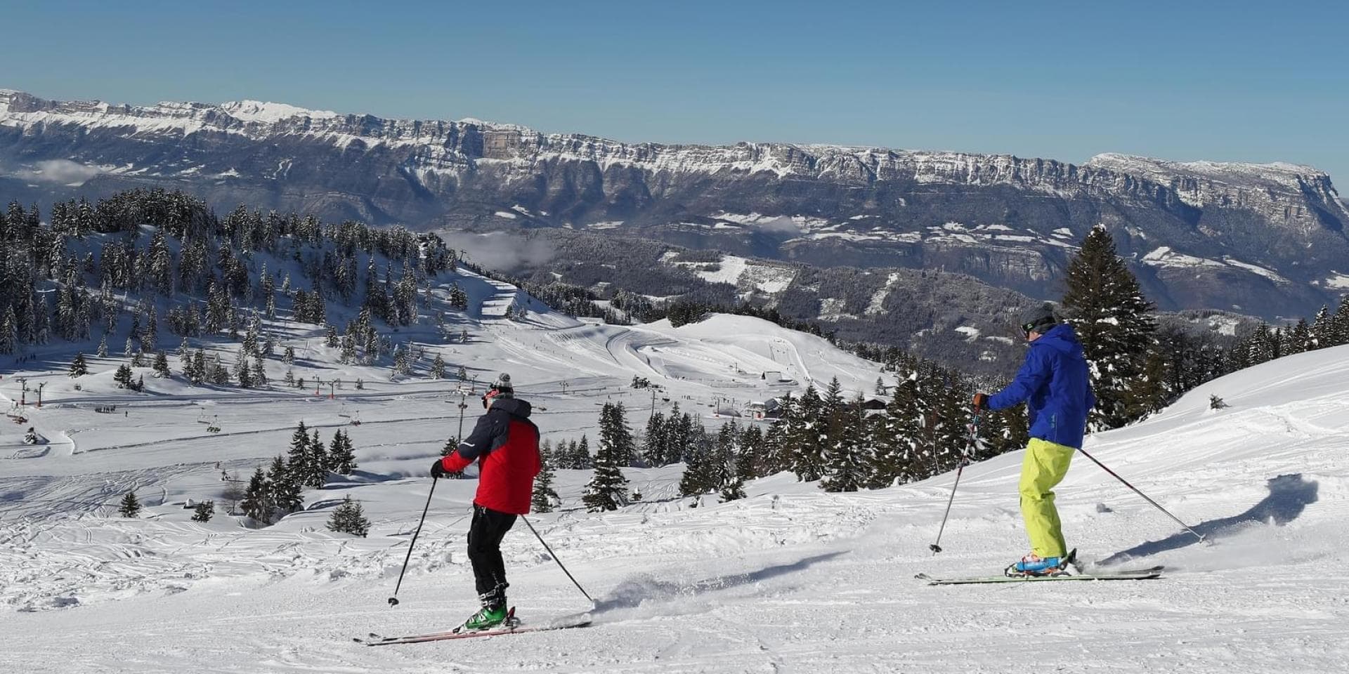 Collet ski resort Allevard in France - two people are skiing down a snowy slope.
