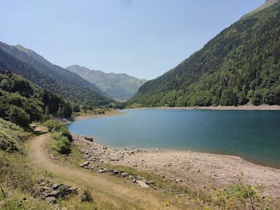 A charming chalet nestled by a serene lake amidst the breathtaking mountain range in Petit train d'Artouste Pyrénées-Atlantiques France bathed beautifully in sunshine.