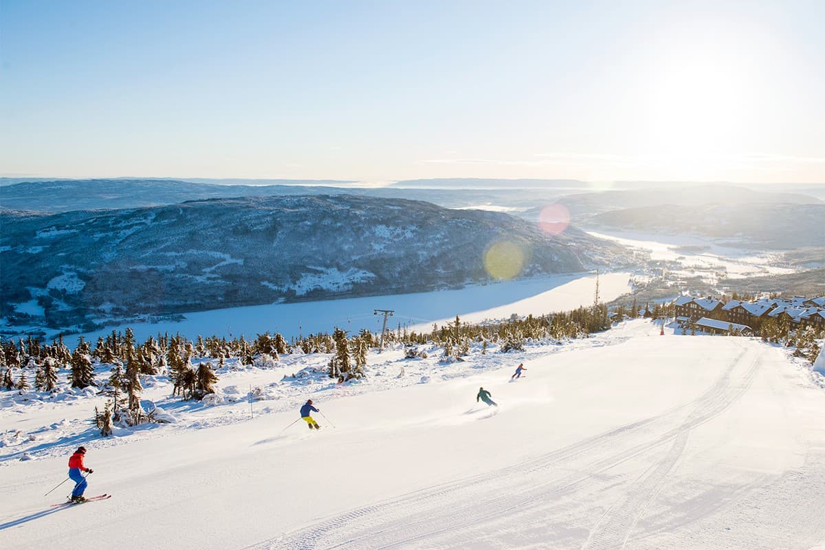 Norefjell in Norway - a group of people skiing down a mountain.