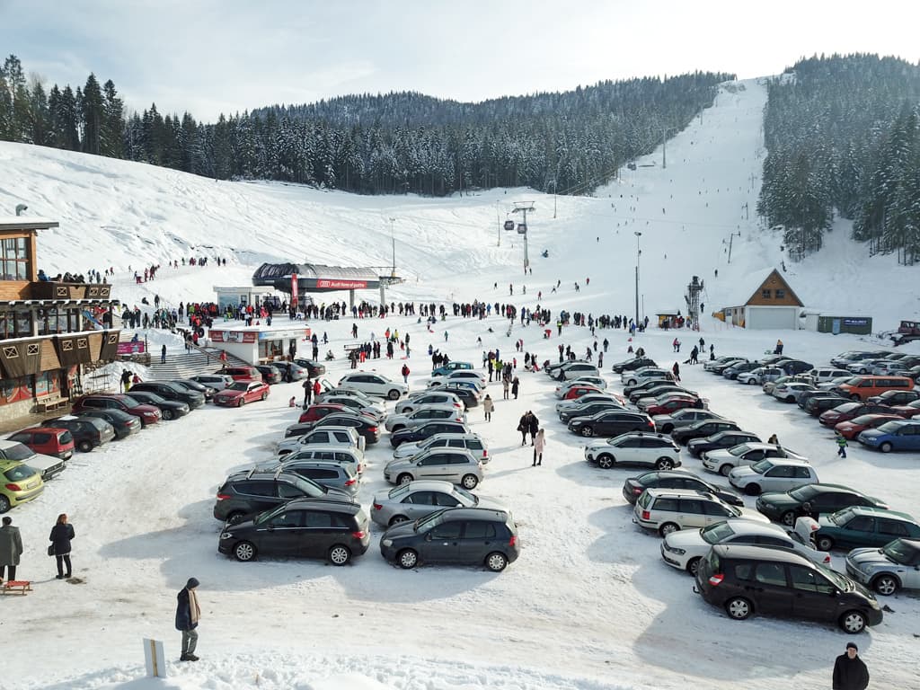 Ravna Planina in Bosnia and Herzegovina - a parking lot filled with cars in the snow.