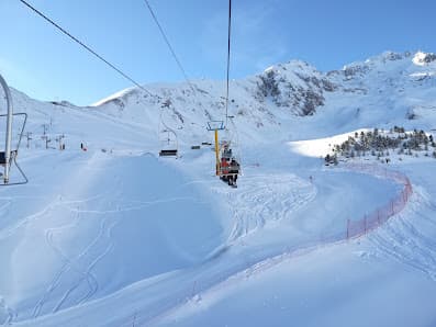 A chalet sits in the French ski resort of Luz Ardiden in the Hautes-Pyrénées region against a snowy winter sports backdrop. A ski lift completes the alpine scene.