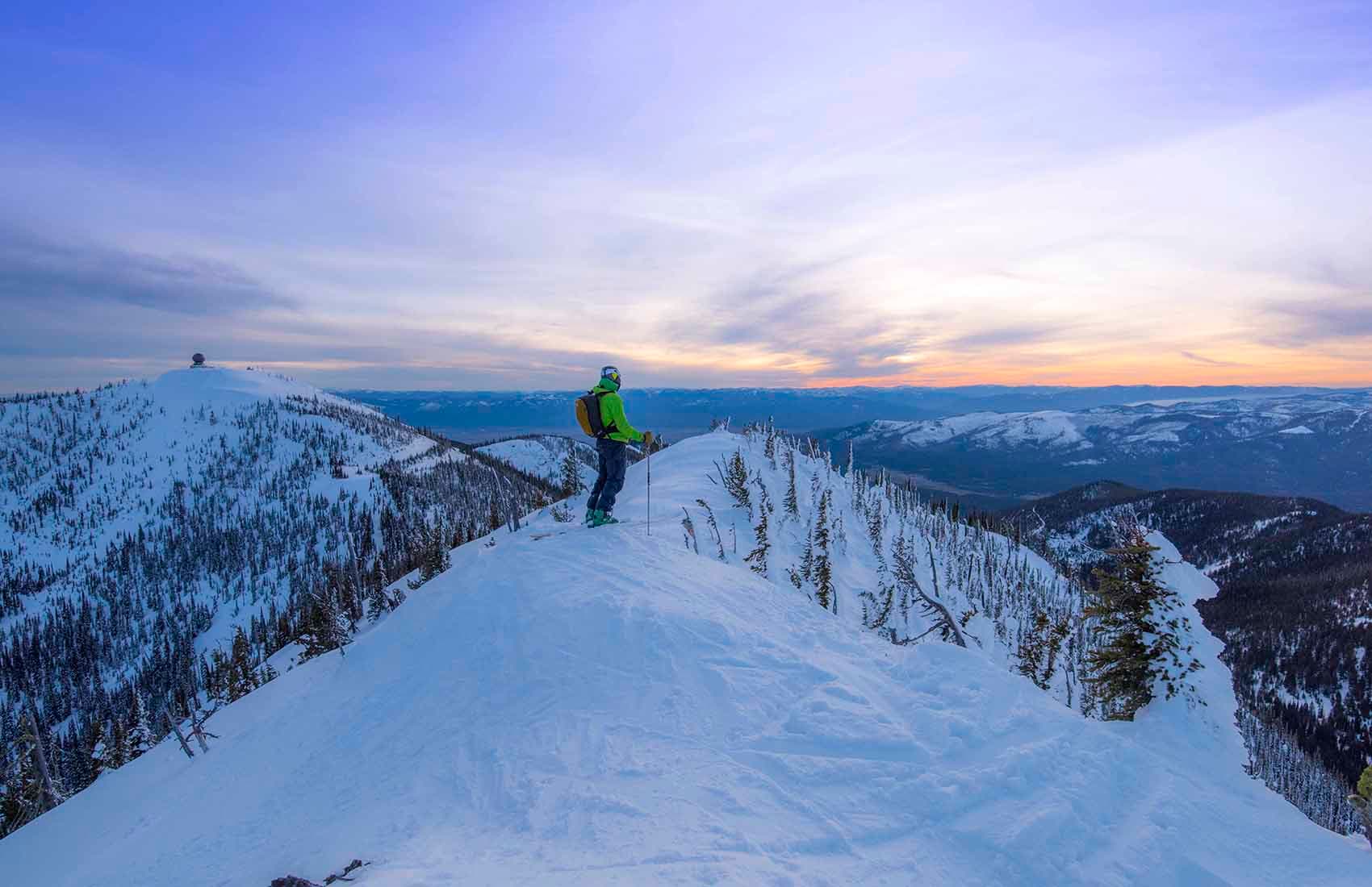 Montana Snowbowl in USA - a person standing on top of a snow covered mountain.