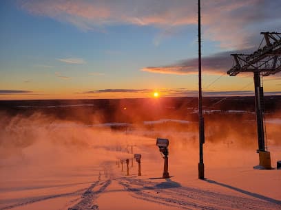 A picturesque winter sports scene in Nikfer Tavas/Denizli Turkey showcasing a ski lift traversing across the snowy ski resort with a skier effortlessly gliding on the slopes amidst the serene winter scenery.
