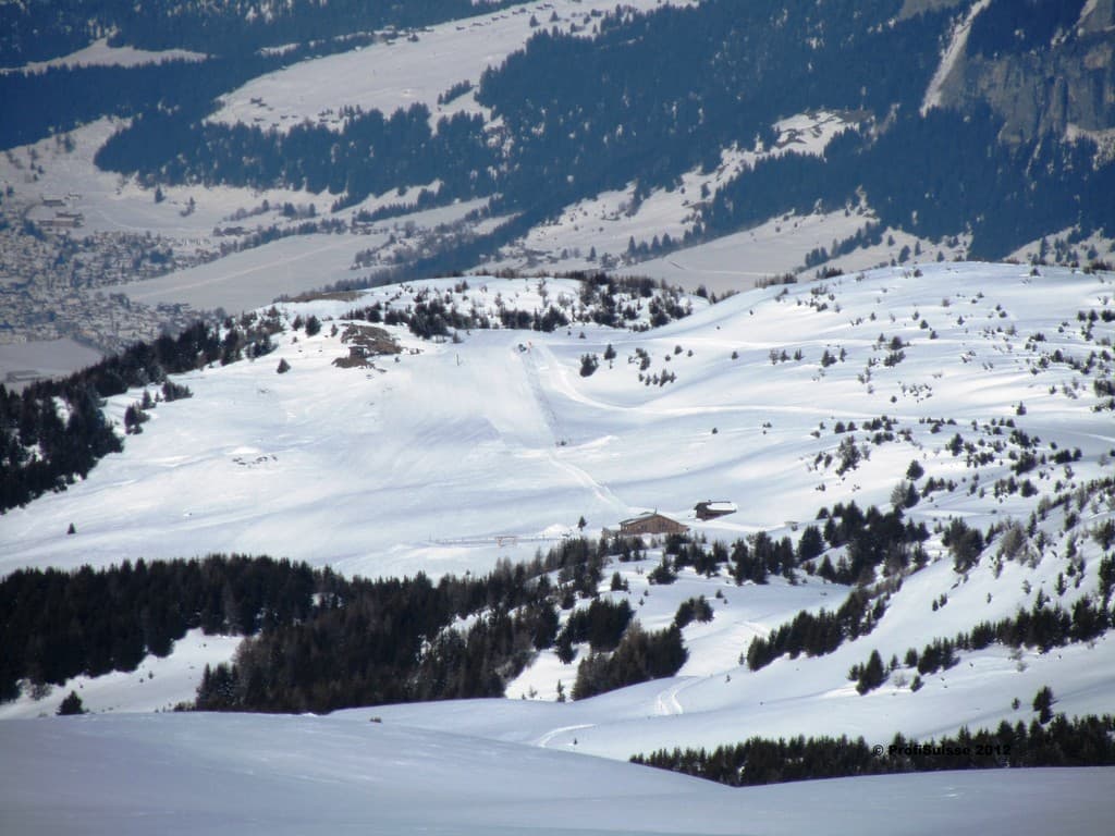 Sesselbahn und Skilifte in Switzerland - a snow covered mountain with trees in the background.