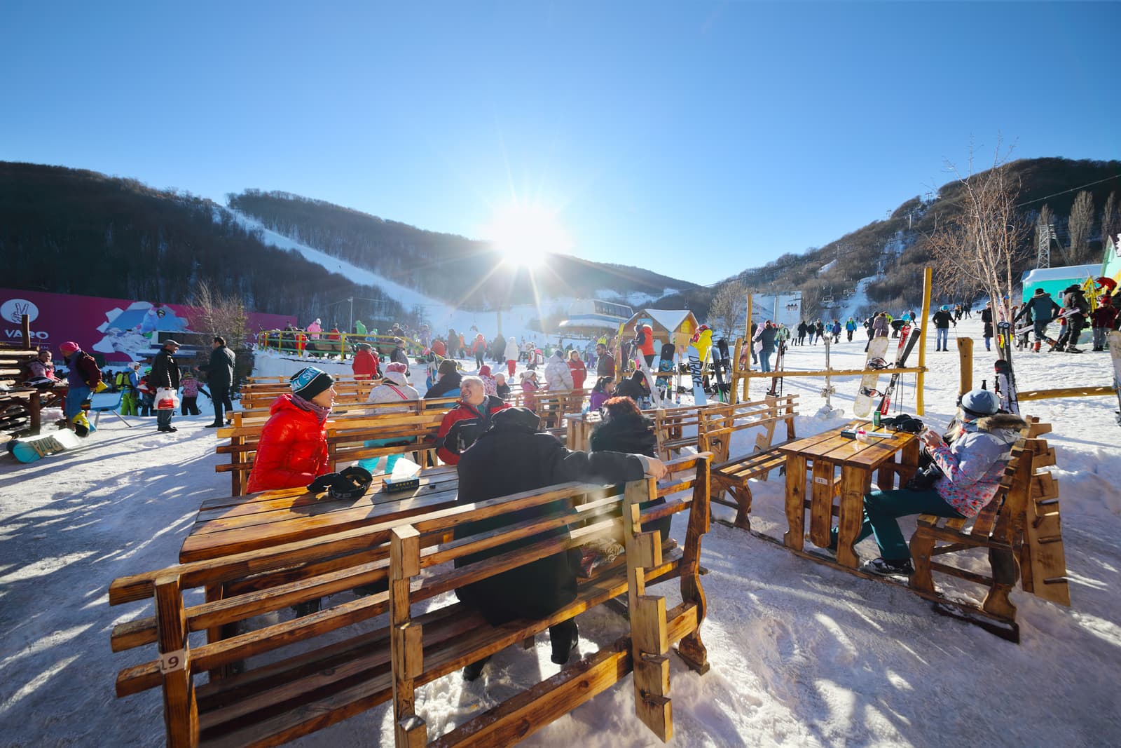 Tsaghkadzor in Armenia - a group of people sitting on benches in the snow.