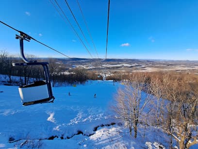 Ski lift ascending a snowy mountain in Tsaghkadzor, Armenia. Skiers and winter sports enthusiasts enjoy the beautiful winter landscape at the ski resort.